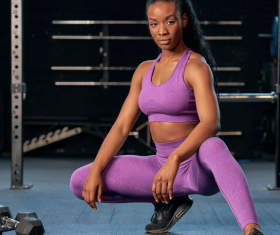 Lady in a squat position with one leg stretched, exercising